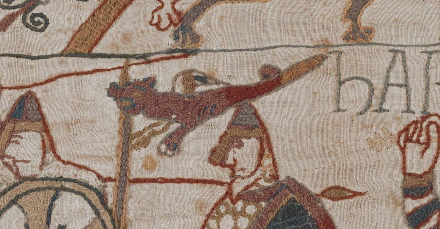A detail of the Bayeux Tapestry showing the English dragon standard, a maroon serpentine beast on a pole, beside the word HAROLD